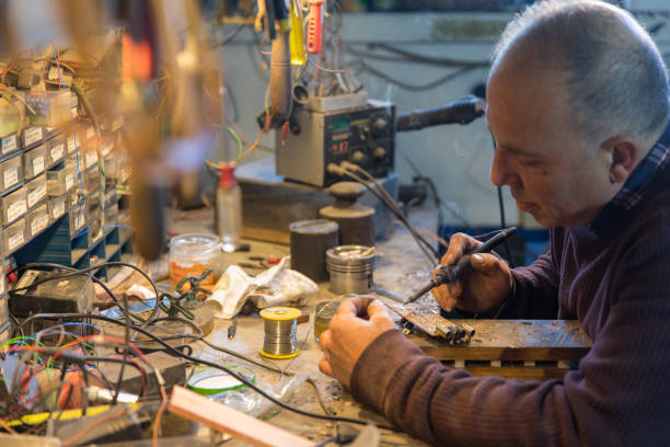 Inventor man solldering electronic circuit board - computer motherboard - repairing