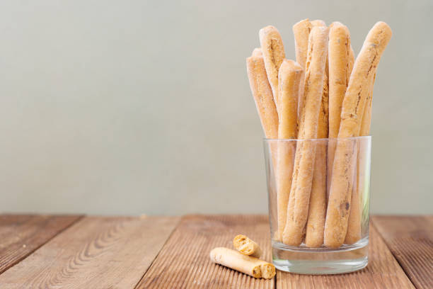 Grissini on wooden table. Traditional italian snack with herbs. Copy space. Fresh italian snack.