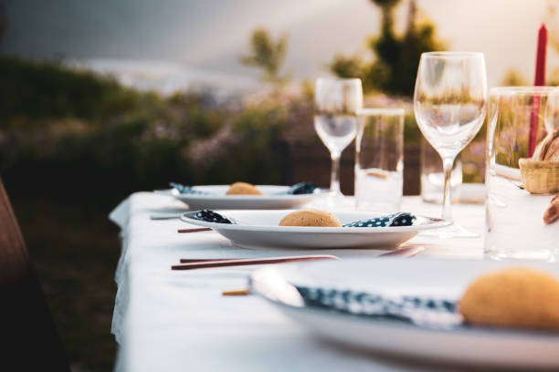 istock An outdoor table setting with wine glasses plates and dinner rolls. Dali, Yunnan, China. 1087318528