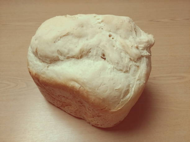 istock Loaf of white bread on a wooden table, object in warm colors, space for text 1087318620