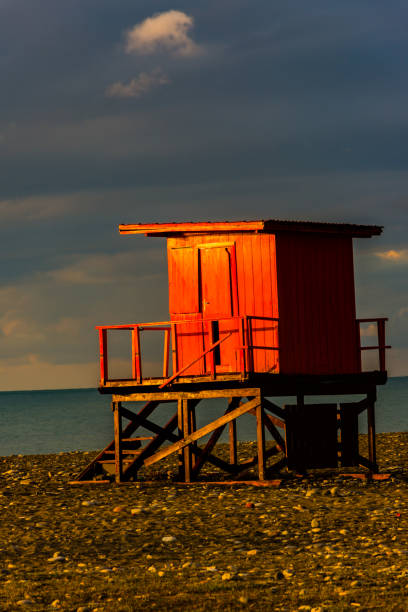 バットのビーチで小さな木の家の照明の日の出 - lifeguard orange nature beach ストックフォトと画像