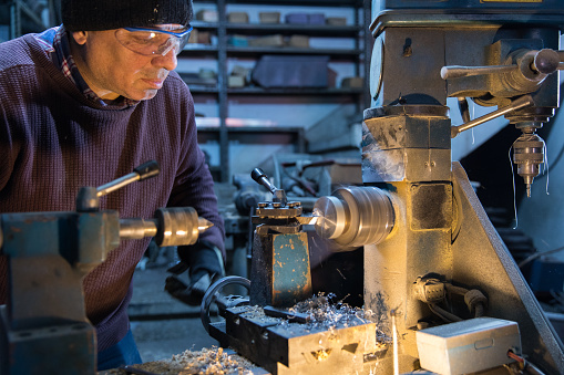 Lathe technician while working on part - Milling machine operator