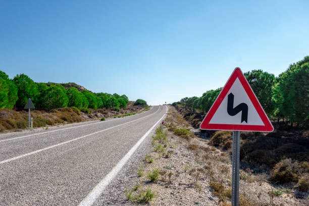 kurvige straße und kein überfahrenes verkehrszeichen - double bend sign fotos stock-fotos und bilder