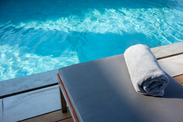 Grey Towel on relaxing pool bed beside swimming pool.