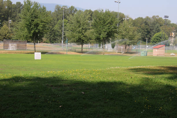 istock A soccer field with three water sprinklers watering it