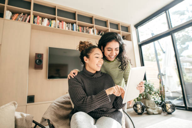 istock Two female friends laughing looking at tablet 1087352044