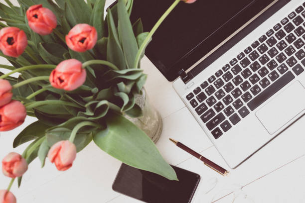 istock laptop and tulips. festive atmosphere in the workplace