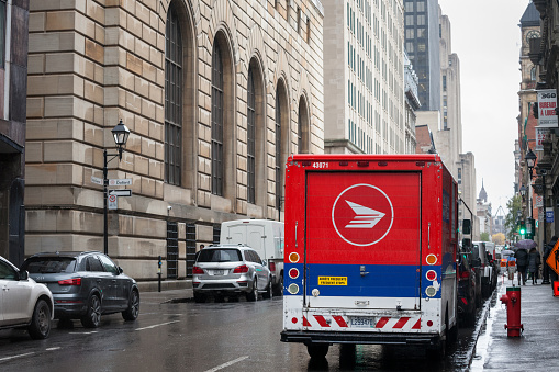 Picture of a delivery van with the logo of Canada Post taken in the streets of Montreal, Quebec, Canada. Canada Post Corporation is a Crown corporation which functions as the primary postal operator in Canada
