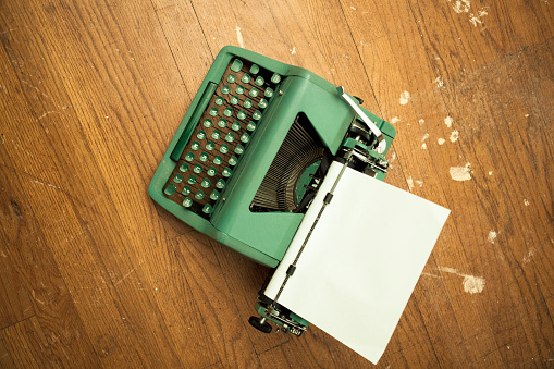 Green Typewriter on Hardwood Floor