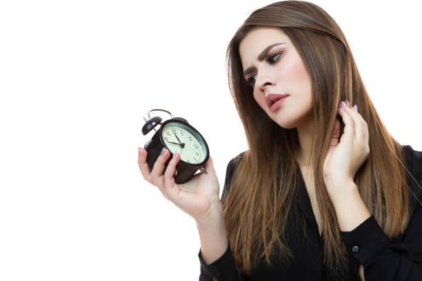 portret kaukaskiej kobiety sprawdzanie czasu z dużym zegarem. przeciwko white'owi. - checking the time time clock women zdjęcia i obrazy z banku zdjęć