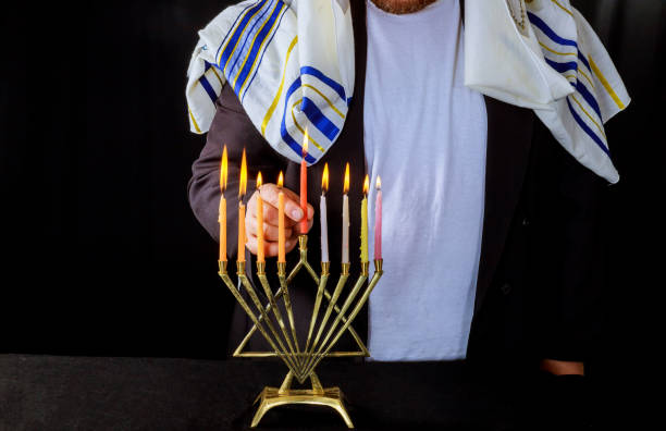 candele a mano sui simboli di hannukah delle festività ebraiche di menorah - hanukkah menorah human hand lighting equipment foto e immagini stock