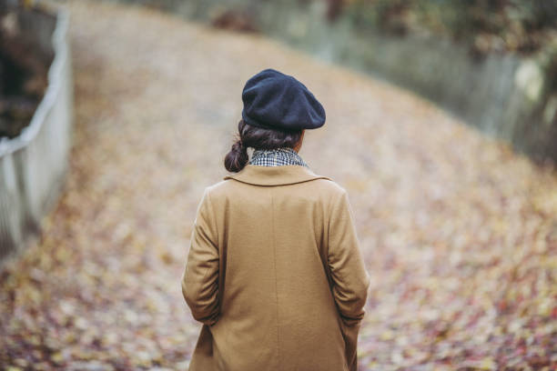 istock Asian woman with fallen leaves 1087373552