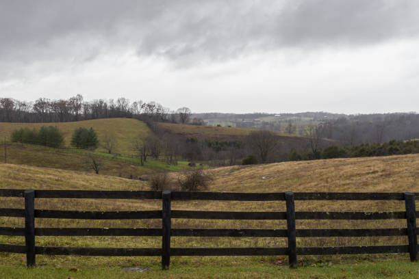 istock Brown ranch fence in front grass covered rolling hills 1087375480