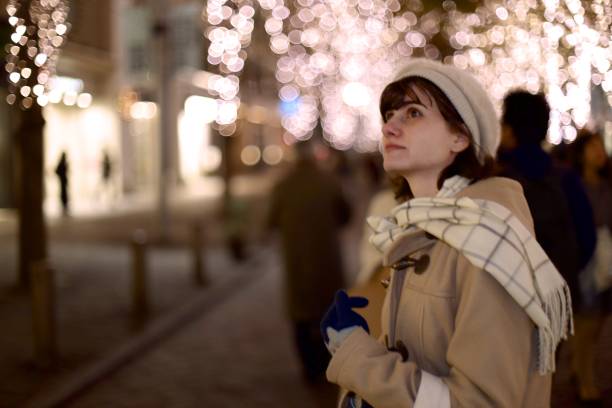 istock Beautiful woman walking along illuminated street 1087380574