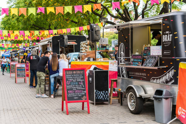 Food trucks and people at a street food market festival on a sunny day stock photo