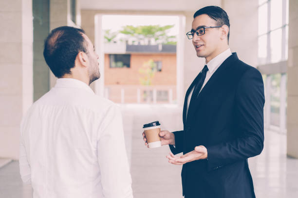istock Confident young consultant talking to client in office corridor 1087397832