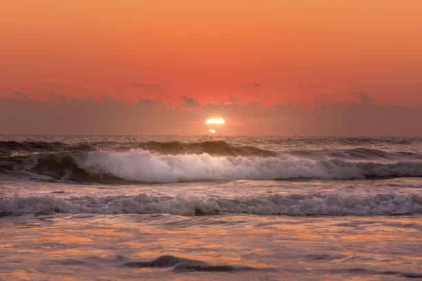 istock Sunrise beach shot with sun rays shining on waves 1087398206