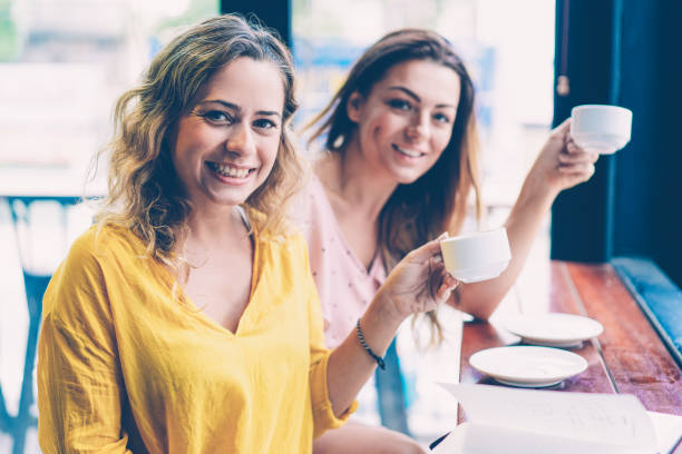 istock Happy young women drinking coffee in cafe 1087401214