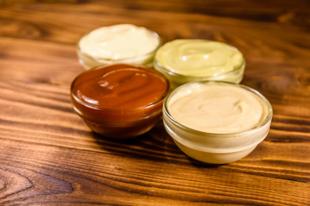 istock Different sauces in glass bowls on wooden table 1087401586
