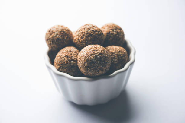 istock Tilgul Laddu or Til Gul balls for makar sankranti, it's a healthy food made using sesame, crushed peanuts and jaggery. served in a bowl. selective focus showing details. 1087403216