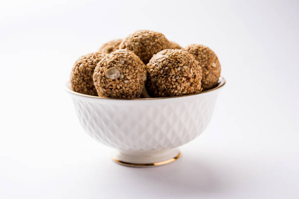 istock Tilgul Laddu or Til Gul balls for makar sankranti, it's a healthy food made using sesame, crushed peanuts and jaggery. served in a bowl. selective focus showing details. 1087405640