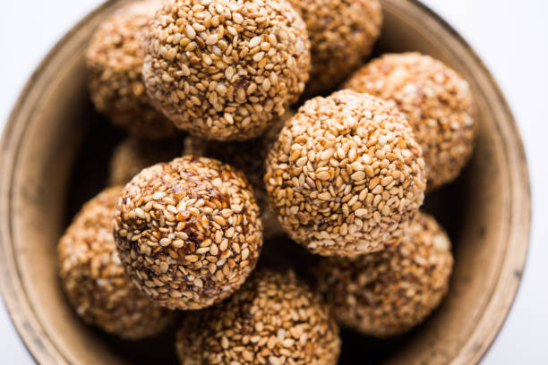 istock Tilgul Laddu or Til Gul balls for makar sankranti, it's a healthy food made using sesame, crushed peanuts and jaggery. served in a bowl. selective focus showing details. 1087407536