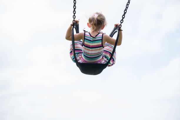 istock Little child swinging on a swing 1087408676