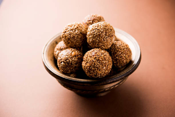 istock Tilgul Laddu or Til Gul balls for makar sankranti, it's a healthy food made using sesame, crushed peanuts and jaggery. served in a bowl. selective focus showing details. 1087411520