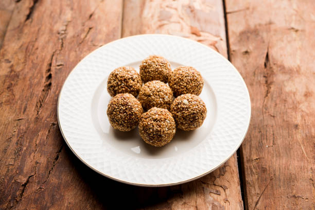 istock Tilgul Laddu or Til Gul balls for makar sankranti, it's a healthy food made using sesame, crushed peanuts and jaggery. served in a bowl. selective focus showing details. 1087415436