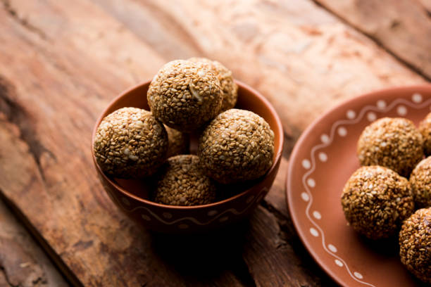 bolas de tilgul laddu o til gul de makar sankranti, es un alimento sano, hecho con sésamo, maní picado y jaggery. sirve en un tazón. detalles de la demostración de enfoque selectivo. - peanut bowl nut circle fotografías e imágenes de stock