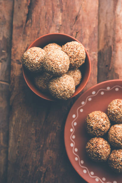 istock Tilgul Laddu or Til Gul balls for makar sankranti, it's a healthy food made using sesame, crushed peanuts and jaggery. served in a bowl. selective focus showing details. 1087417980