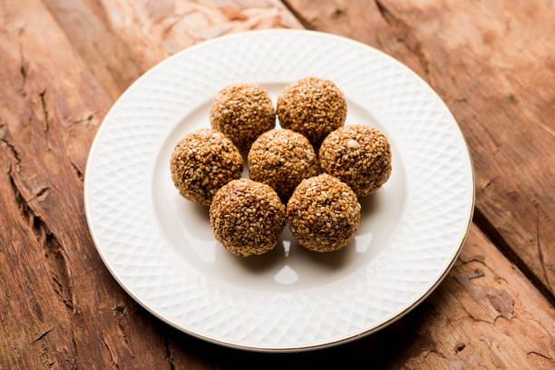 istock Tilgul Laddu or Til Gul balls for makar sankranti, it's a healthy food made using sesame, crushed peanuts and jaggery. served in a bowl. selective focus showing details. 1087420112