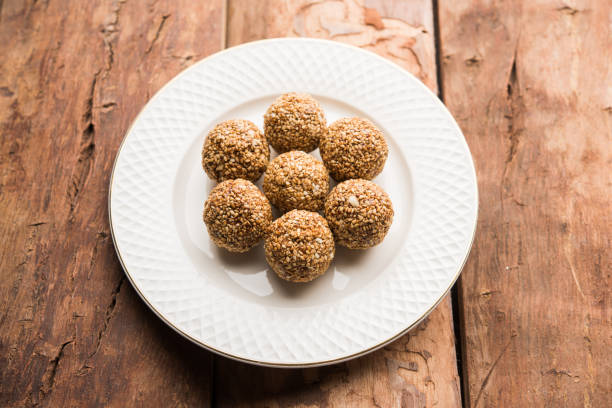 istock Tilgul Laddu or Til Gul balls for makar sankranti, it's a healthy food made using sesame, crushed peanuts and jaggery. served in a bowl. selective focus showing details. 1087420118