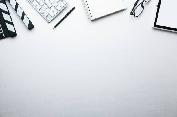 istock Movie clapper, keyboard and other objects on white desk. 1087422640
