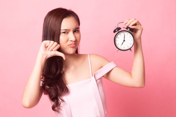 istock Young Asian woman is stressed with a clock. 1087425298