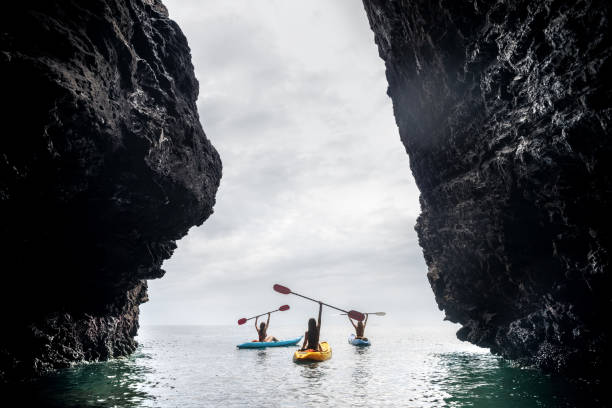 kayakers felici kayaks sea rock walk kayak - extreme sports kayaking kayak adventure foto e immagini stock