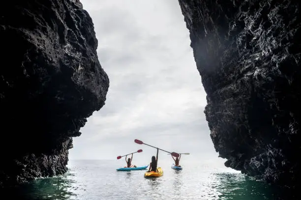 Photo of Happy kayakers sea rock walk kayaks