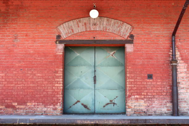 istock Strong rusted metal doors on red brick building connected to trucks unloading bay 1087434632