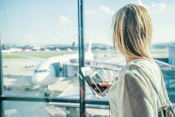 Female at airport in terminal waiting for departure flight Young woman in airport waiting for flight sitting on bench with phone and passport in hands airplane ticket photos stock pictures, royalty-free photos & images