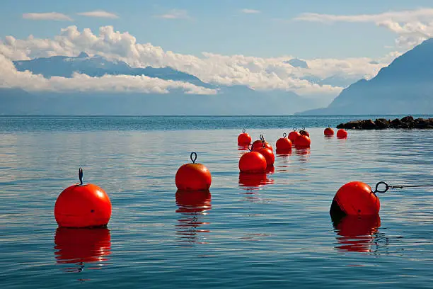 Orange anchor buoys on a surface of quiet lake in mountains