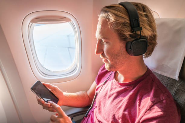 istock One male in airplane text messaging on mobile phone 1087441524