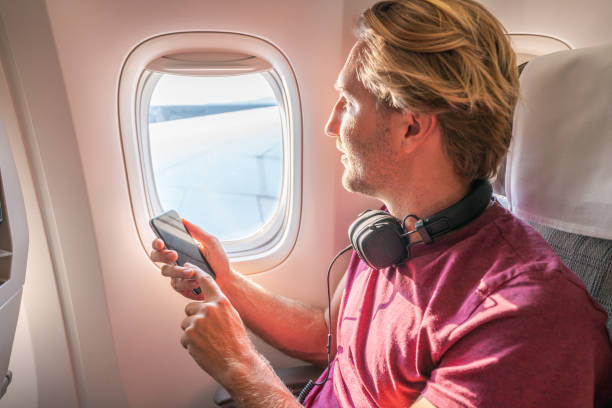 istock One male in airplane text messaging on mobile phone 1087441910