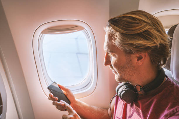 istock One male in airplane text messaging on mobile phone 1087442192