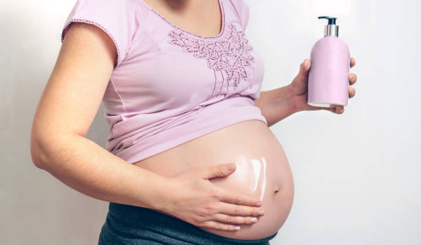 istock Pregnant applying anti-stretch mark cream 1087447406