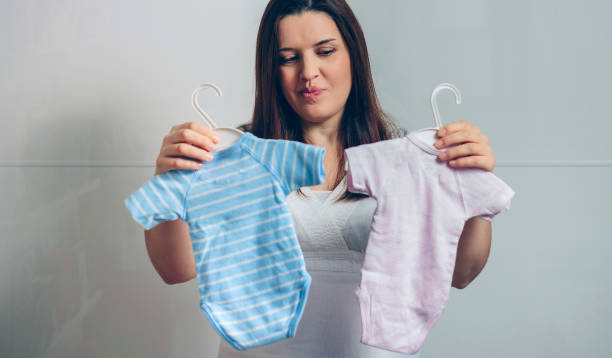 istock Pregnant choosing baby bodysuits 1087447432