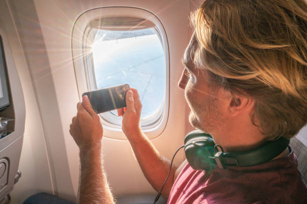 istock Travel man photographing view from airplane seat 1087448558