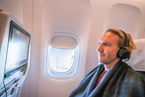istock Airplane passenger enjoying onboard entertainment in comfortable seat 1087448672