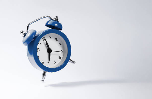 The dark blue alarm clock bounces against the background. Concept of deadline and business cases completed on time.