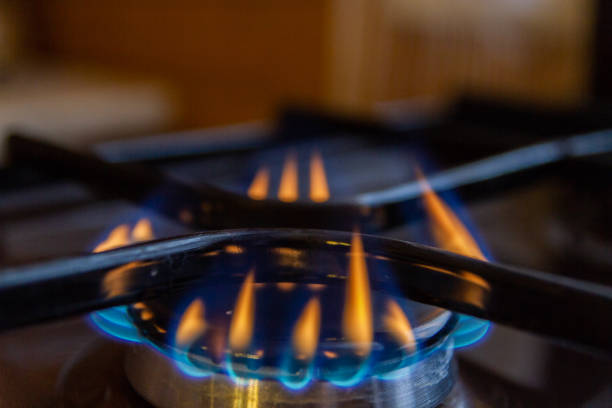 Gas stove with burning orange and blue fire on it
