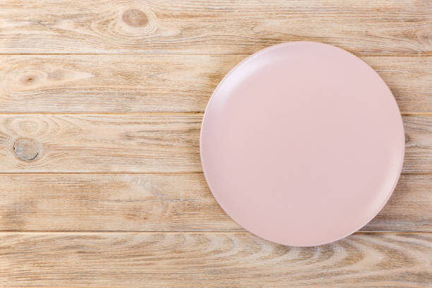 istock Directy above Empty pink matte dish for dinner on wooden orange background with copy space 1087462700